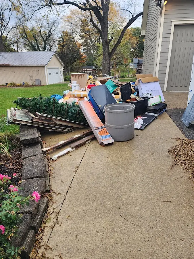 Dumpster being loaded with debris for Estate Cleanout Dumpster Rental in Le Claire
